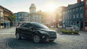 A black 2019 Ford Escape driving on a city street.