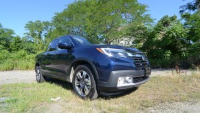 A 2019 Honda Ridgeline sits in a field. You can find this used truck for less than $30,000.