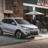 A silver 201 Chevrolet Spark parked out doors, which is the Chevrolet with the lowest insurance cost.