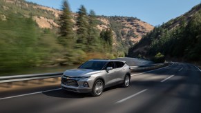 A 2022 Chevy Blazer, where Blazer Insurance costs may be needed as it drives down the road in a wooded area.