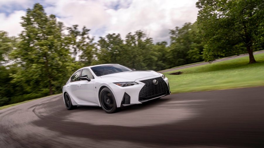 A new white 2023 Lexus IS 350 blasts around a corner faster than an IS 300 could.