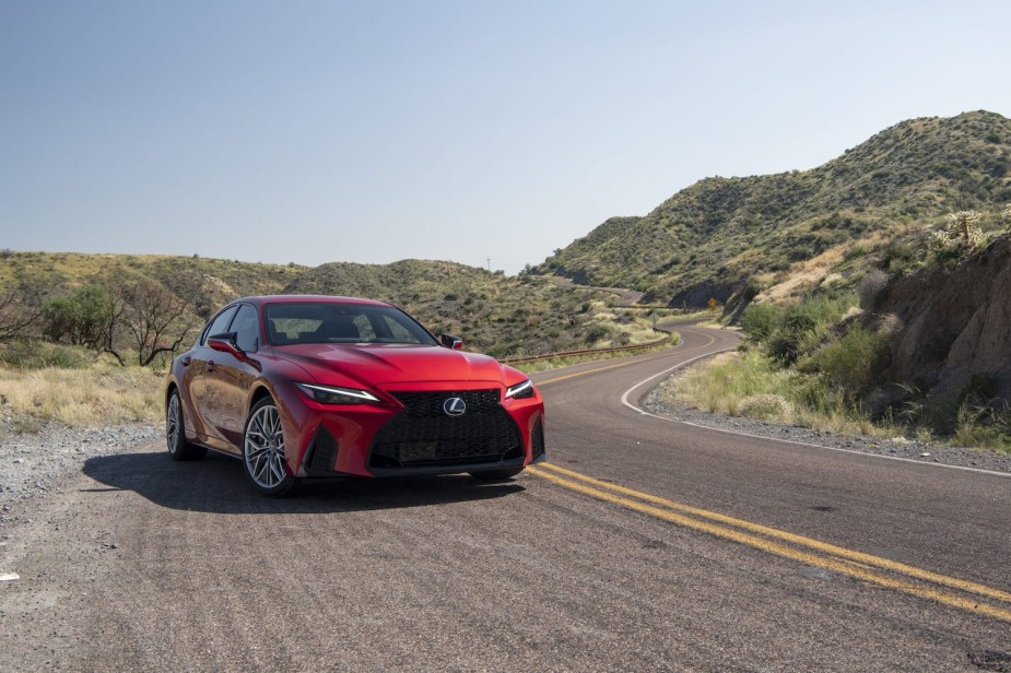 Promo photo of a red Lexus LS 500 sedan parked on a winding mountain road.