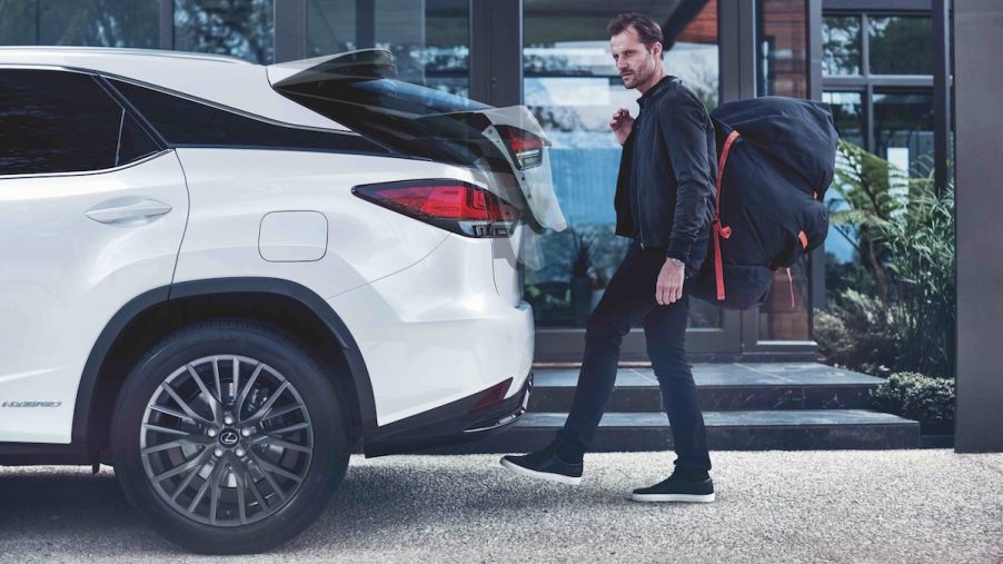 A white 2022 Lexus RX350 with someone walking to it, which is one of the best luxury hybrid third-row SUVs.