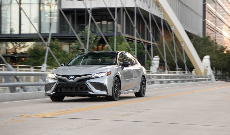 A 2023 Toyota Camry LE cruises urban streets while showing off its silver paint job. 