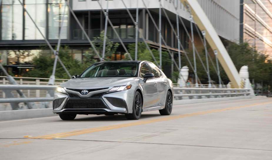 A brand new Toyota Camry, one of the car company's most popular cars, shows off its silver paintwork as it cruises city streets.