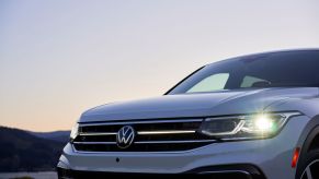 A closeup exterior shot of the grille and headlights of a white 2022 Volkswagen Tiguan SEL R-Line compact SUV model