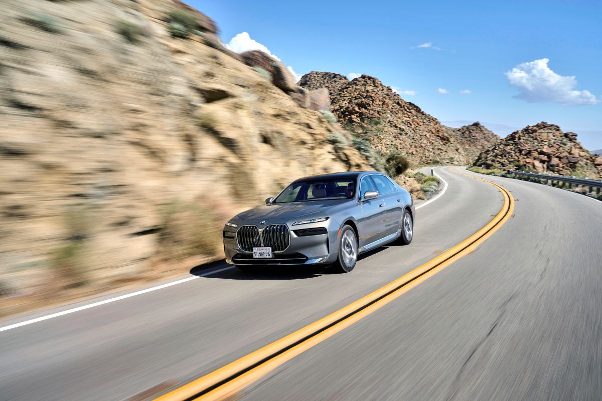 A nice luxury sedan drives down a road in a canyon