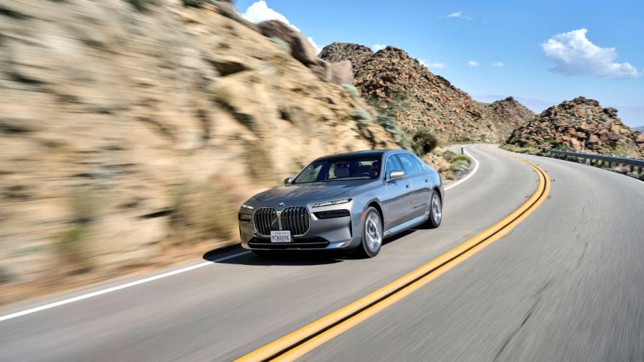 A nice luxury sedan drives down a road in a canyon