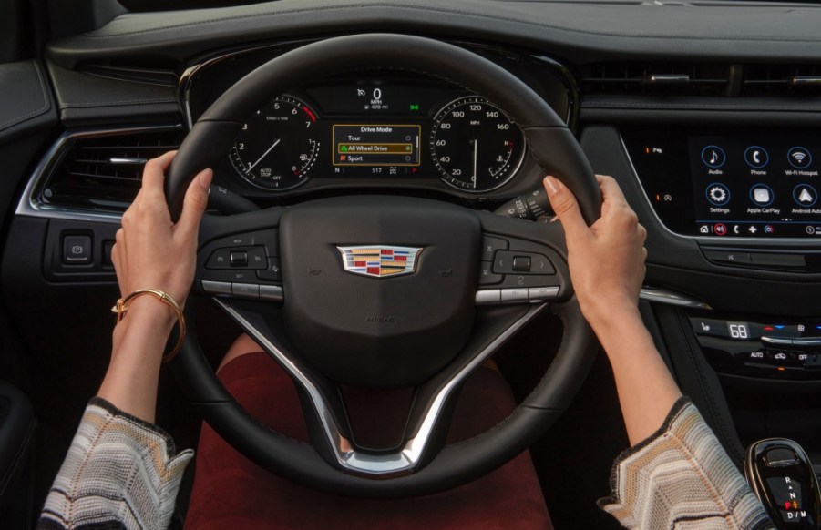 A person with their hands on a the steering wheel of a 2023 Cadillac XT6.