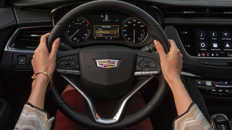 A person with their hands on a the steering wheel of a 2023 Cadillac XT6.