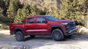 Red 2023 Chevy Colorado Midsize Truck posed on a gravel trail