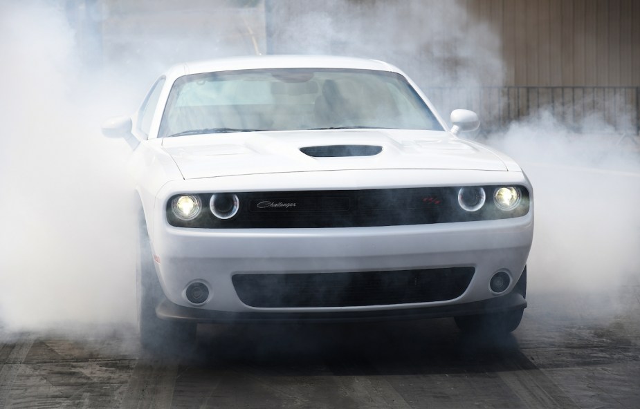 Promo photo of the 2023 Dodge Challenger R/T Scat Pack 1320 package doing a burnout, a could of smoke visible in the background.