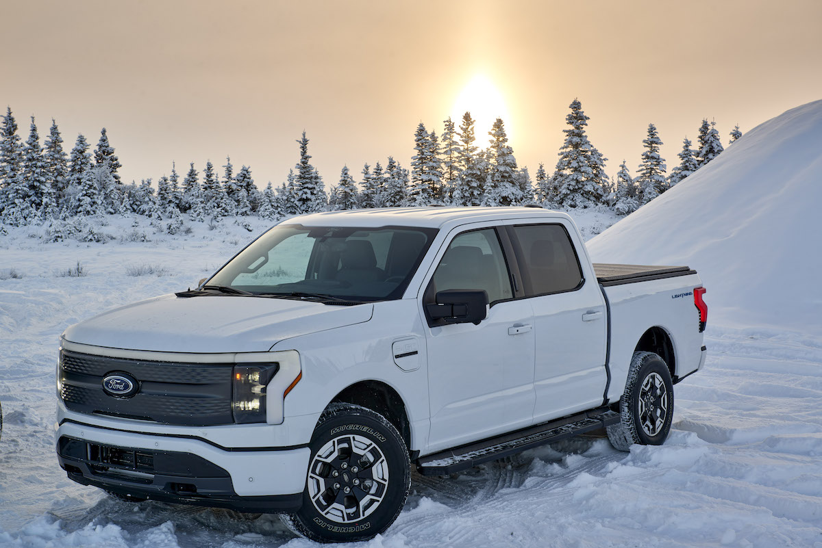 A white 2023 Ford F-150 Lightning in the snow.