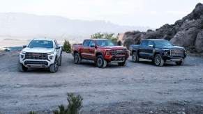 Three different 2023 GMC Canyon trucks lined up on a road.