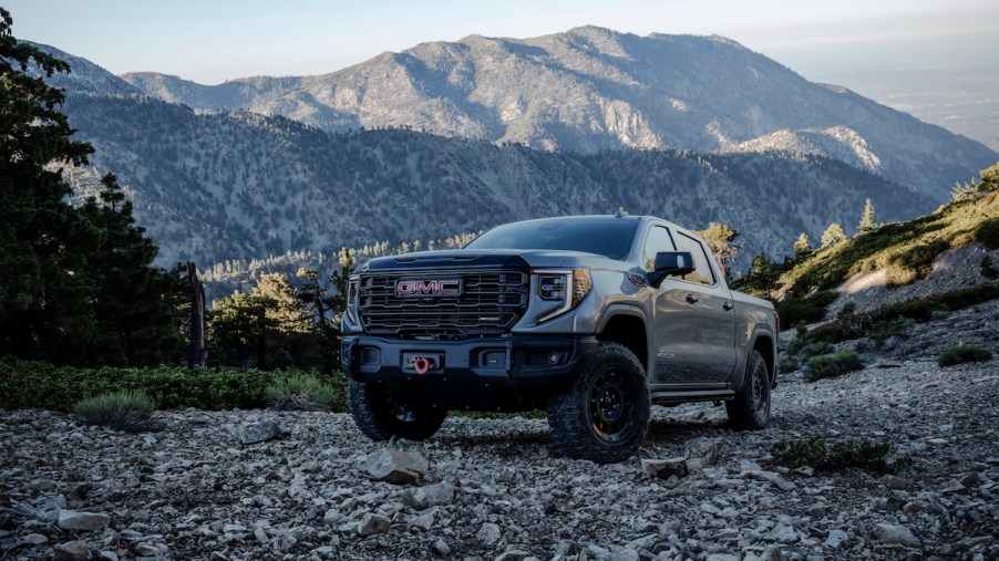 A 2023 GMC Sierra parked in front of a mountain side, which is the truck with the most horsepower.