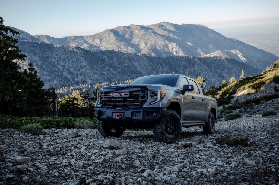 A 2023 GMC Sierra parked in front of a mountain side, which is the truck with the most horsepower. 