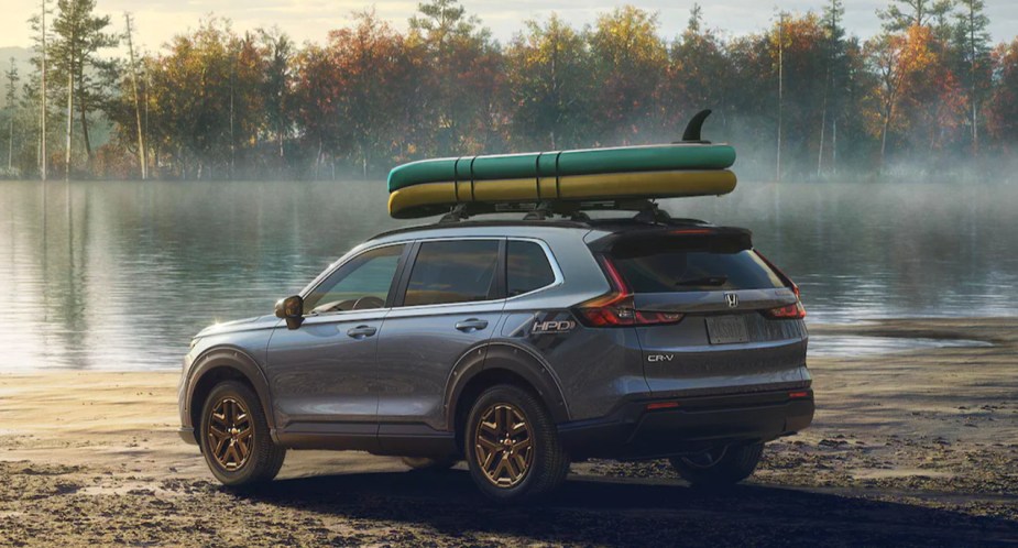 A gray 2023 Honda CR-V small SUV is parked outdoors next to a body of water. 