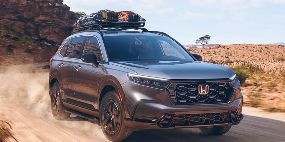 A gray 2023 Honda CR-V small SUV is driving on the road. 