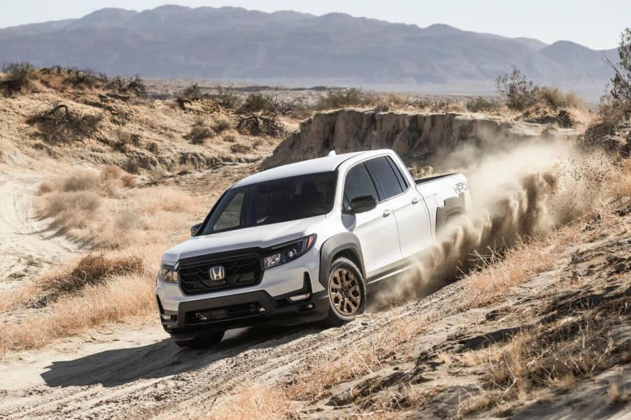 A white 2023 Honda Ridgeline blasts over a hill.