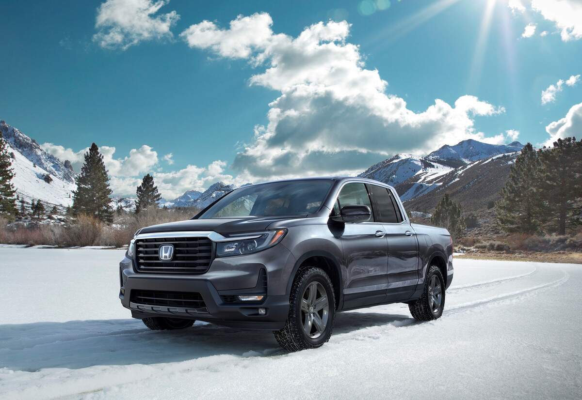 A blue Honda Ridgeline parked in a snowy environment.