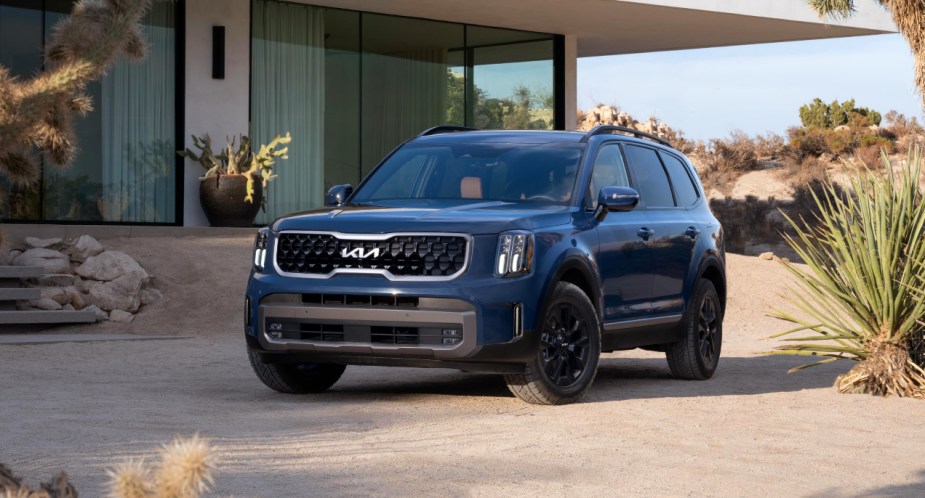 A blue 2023 Kia Telluride midsize SUV is parked outdoors.