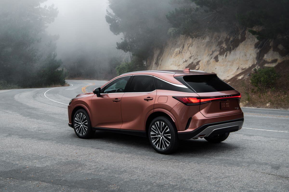 2023 Lexus RX 350 Premium AWD luxury SUV model in Copper parked on a foggy highway mountain road