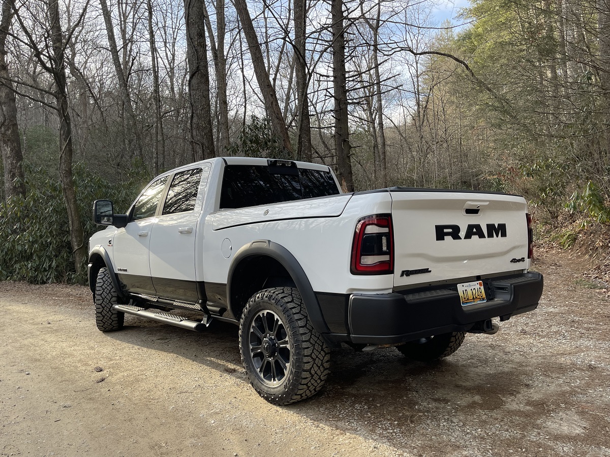 Promo photo of a white 2023 Ram 2500 HD Rebel with in-bed Ram box Cargo Boxes.