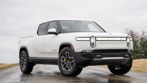A white Rivian R1T parked on a road.
