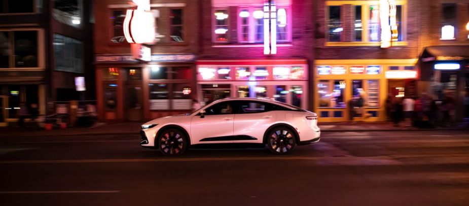 A 2023 Toyota Crown Platinum trim driving down a street at night.
