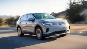A gray 2023 Volkswagen ID.4 small electric SUV is driving on the road.