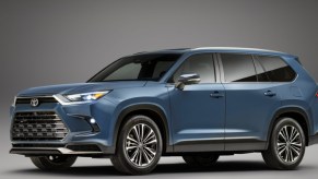 A blue 2024 Toyota Grand Highlander midsize SUV is parked.