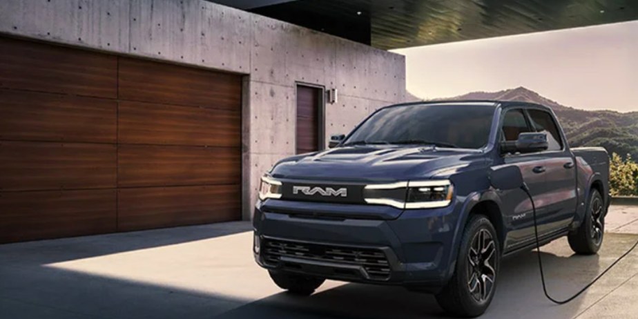 A blue 2025 Ram 1500 REV full-size electric pickup truck is charging.
