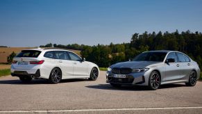 The new white BMW 3 Series Touring and gray BMW 3 Series Sedan models