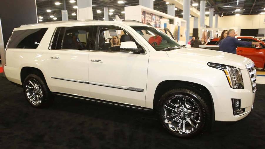 A white Cadillac Escalade parked indoors.