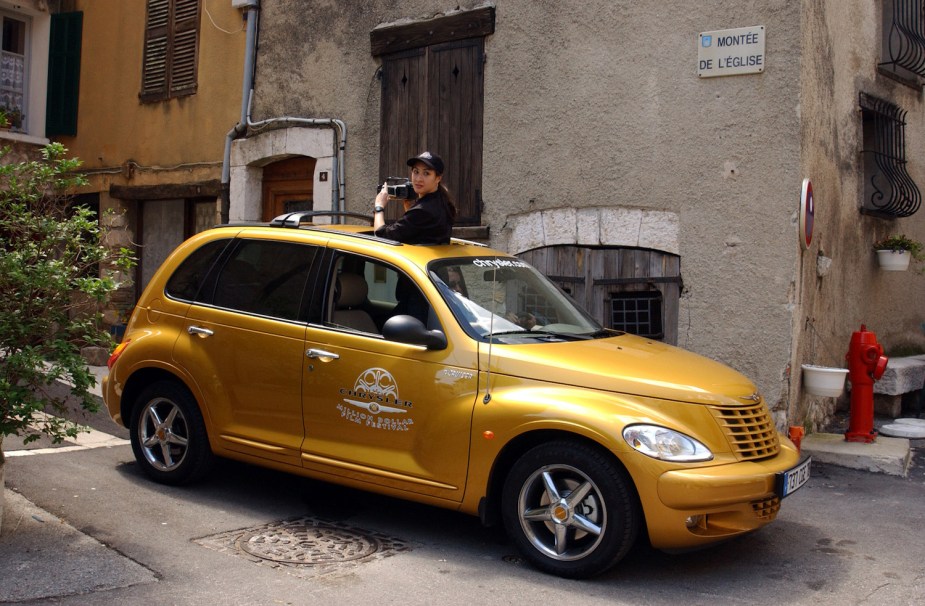 A golden-colored PT Cruiser parked on the street in France.