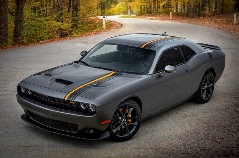 A 2023 Dodge Challenger shows off its striped gray paint work and muscle car styling on a back road.