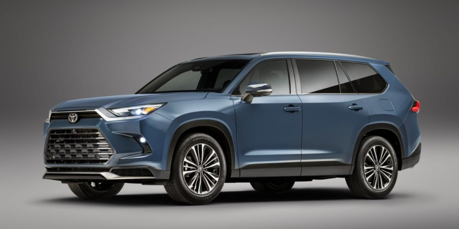 A blue 2024 Toyota Grand Highlander midsize SUV is parked.