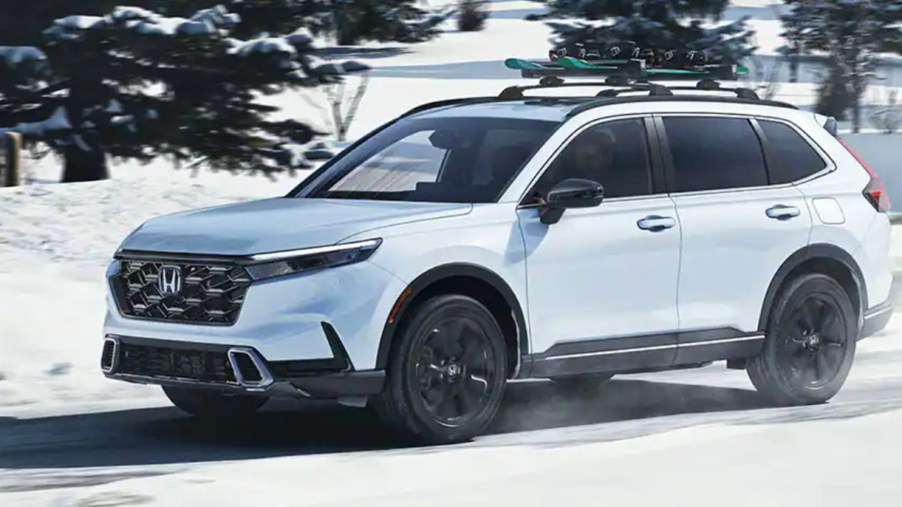 A white 2023 Honda CR-V is driving in the snow.