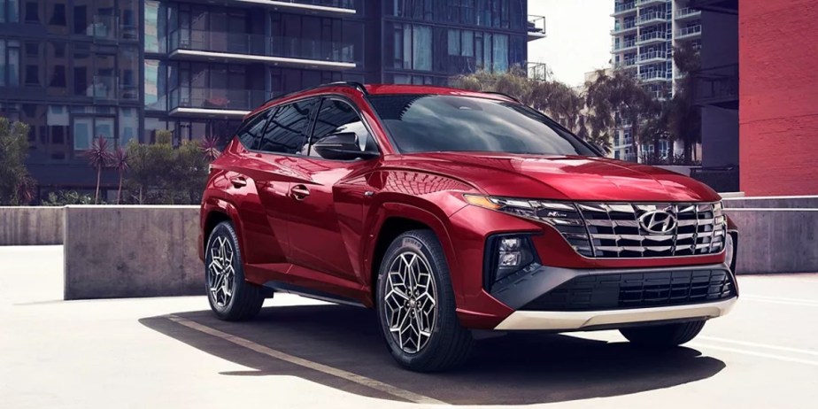 A red 2023 Hyundai Tucson small SUV is parked. 