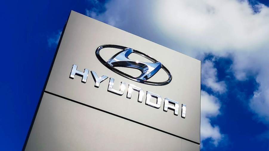 A Hyundai Motor Group logo on a sign. Compare the Hyundai annual maintenance costs, including the 90s Hyundai Scoupe.