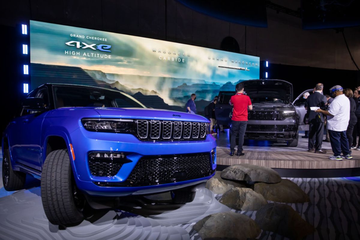 A blue Jeep Grand Cherokee 4xe on display at an auto show