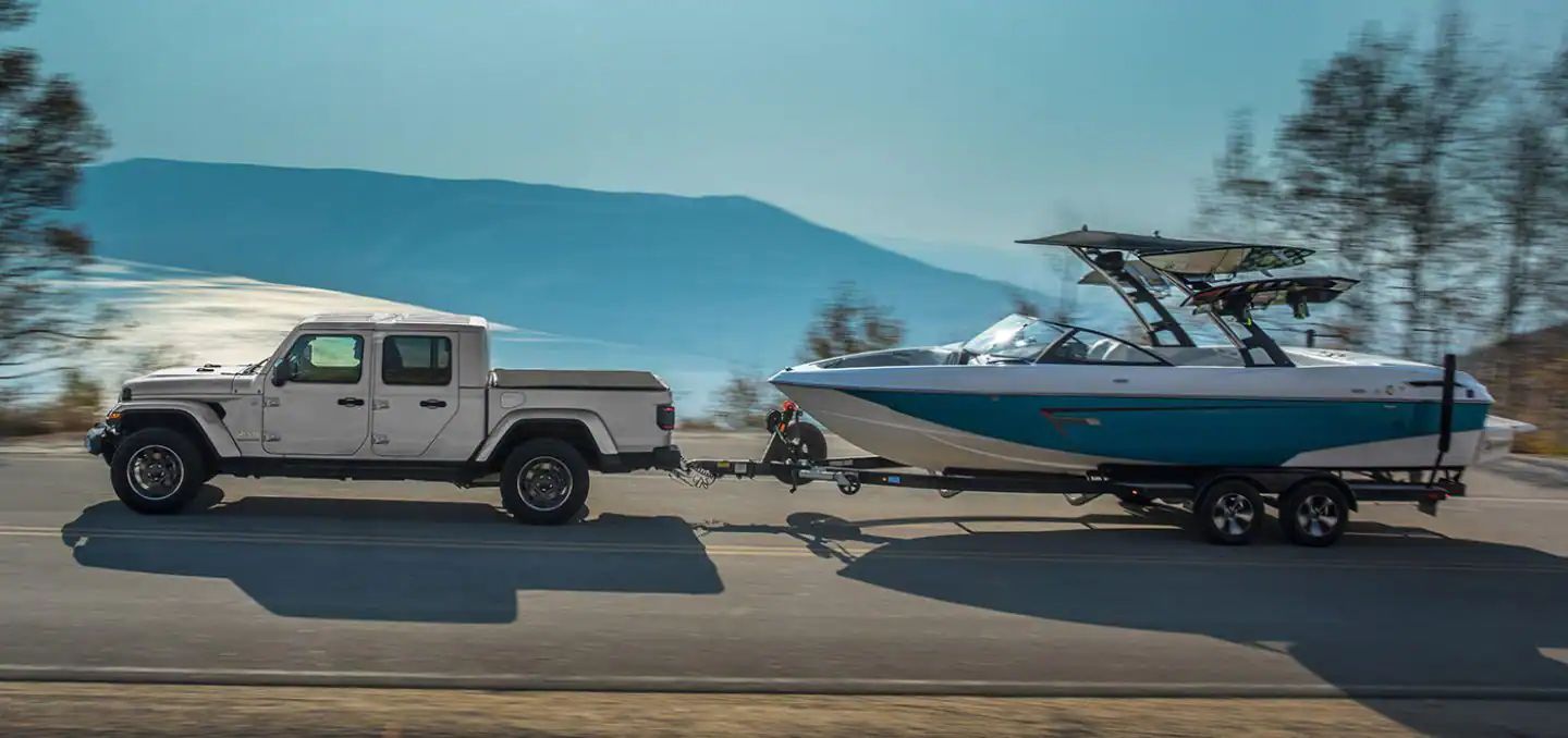 The 2023 Jeep Gladiator is towing a boat. It is the last midsize pickup with a diesel powertrain.