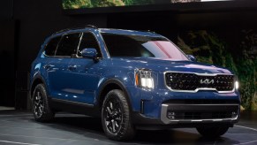 A blue Kia Telluride parked indoor.