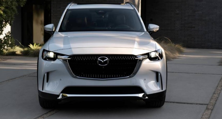 A white 2024 Mazda CX-90 PHEV midsize SUV is parked. 