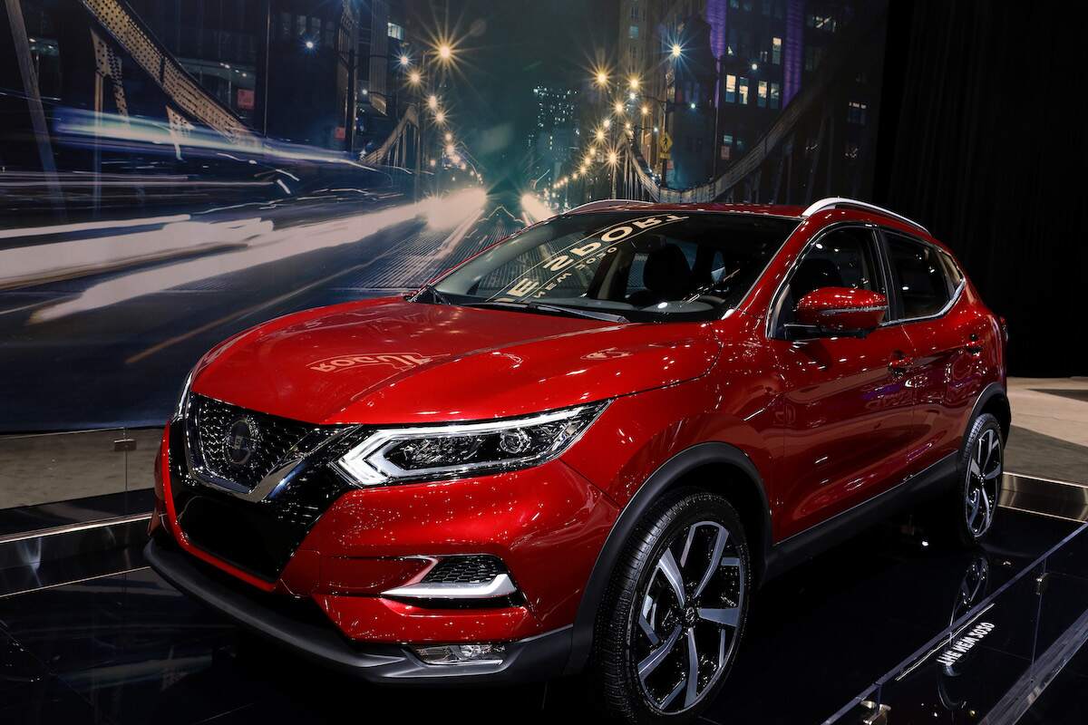 A red Nissan Rogue parked indoors.
