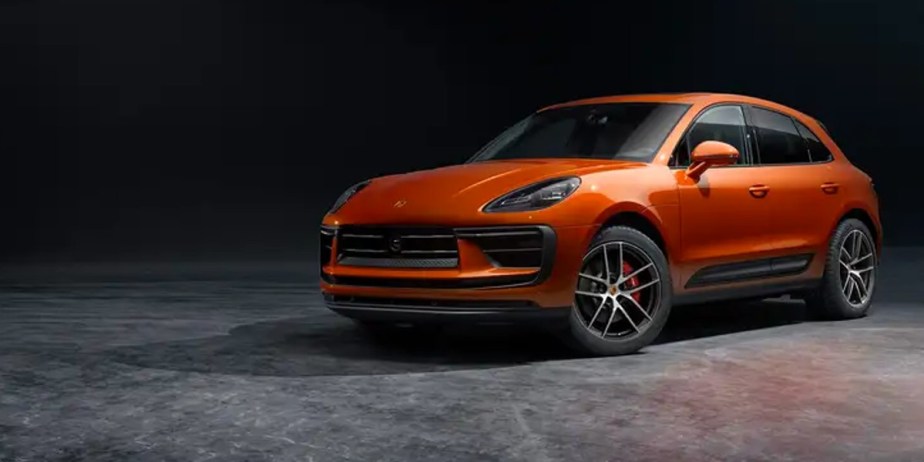 An orange 2023 Porsche Macan compact luxury SUV is parked. 
