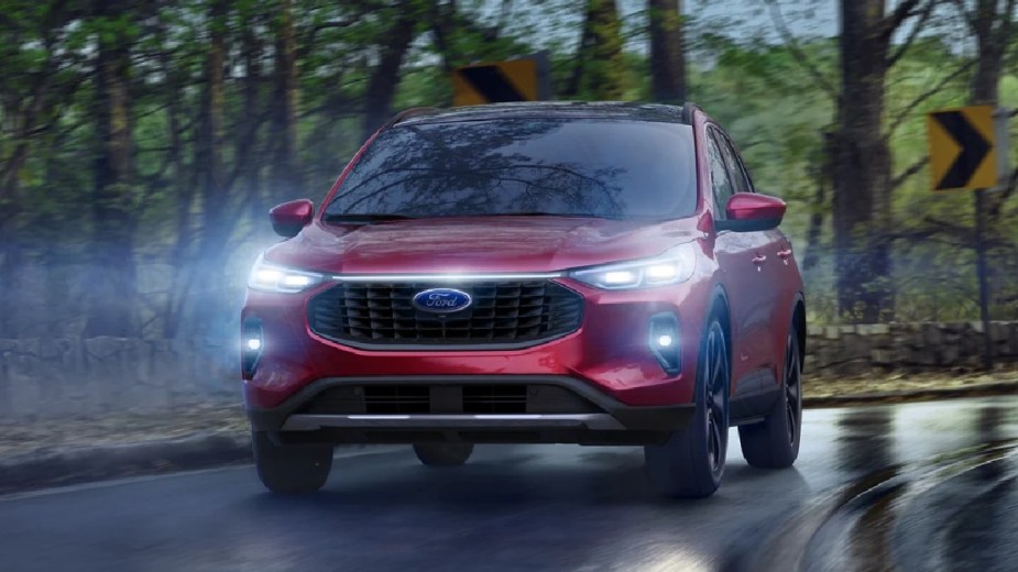 Red 2023 Ford Escape crossover SUV driving on curvy road