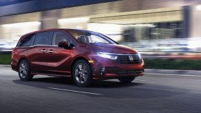 Red 2023 Honda Odyssey driving at night
