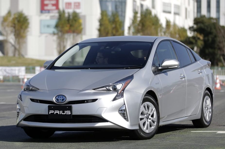 A silver Toyota Prius hybrid shows off its front end styling on urban streets. 