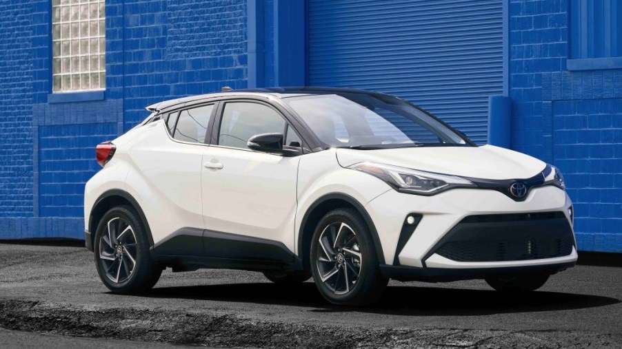 A white 2022 Toyota C-HR subcompact SUV is parked on the sidewalk.